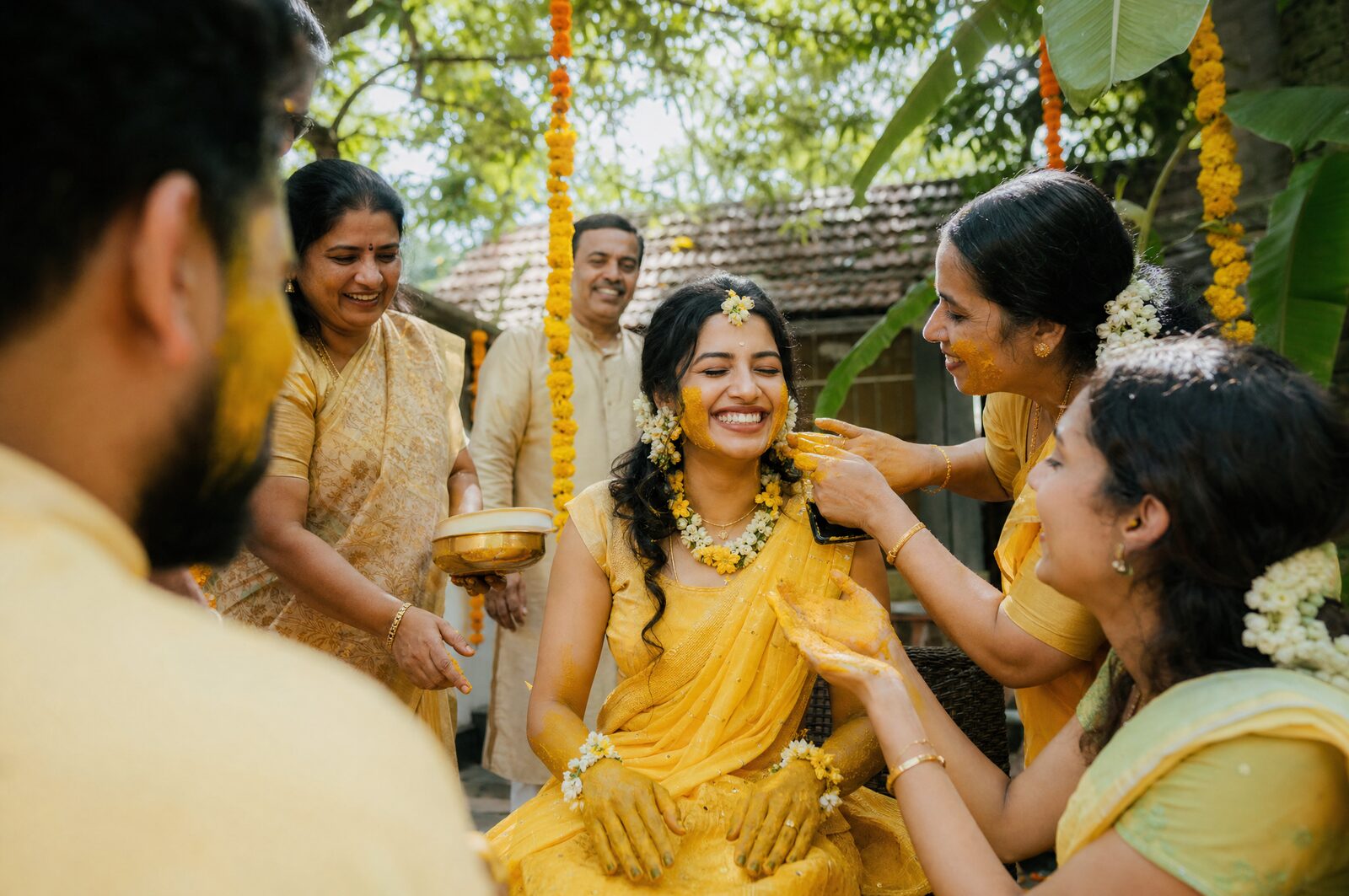 A bride laughing during a haldi ceremony in a Kerala courtyard