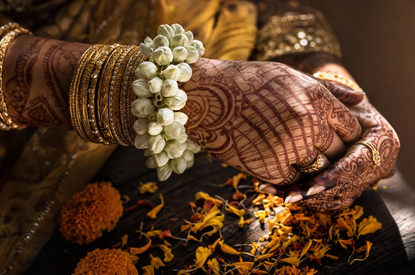 A bride's hands with fresh henna and gold bangles