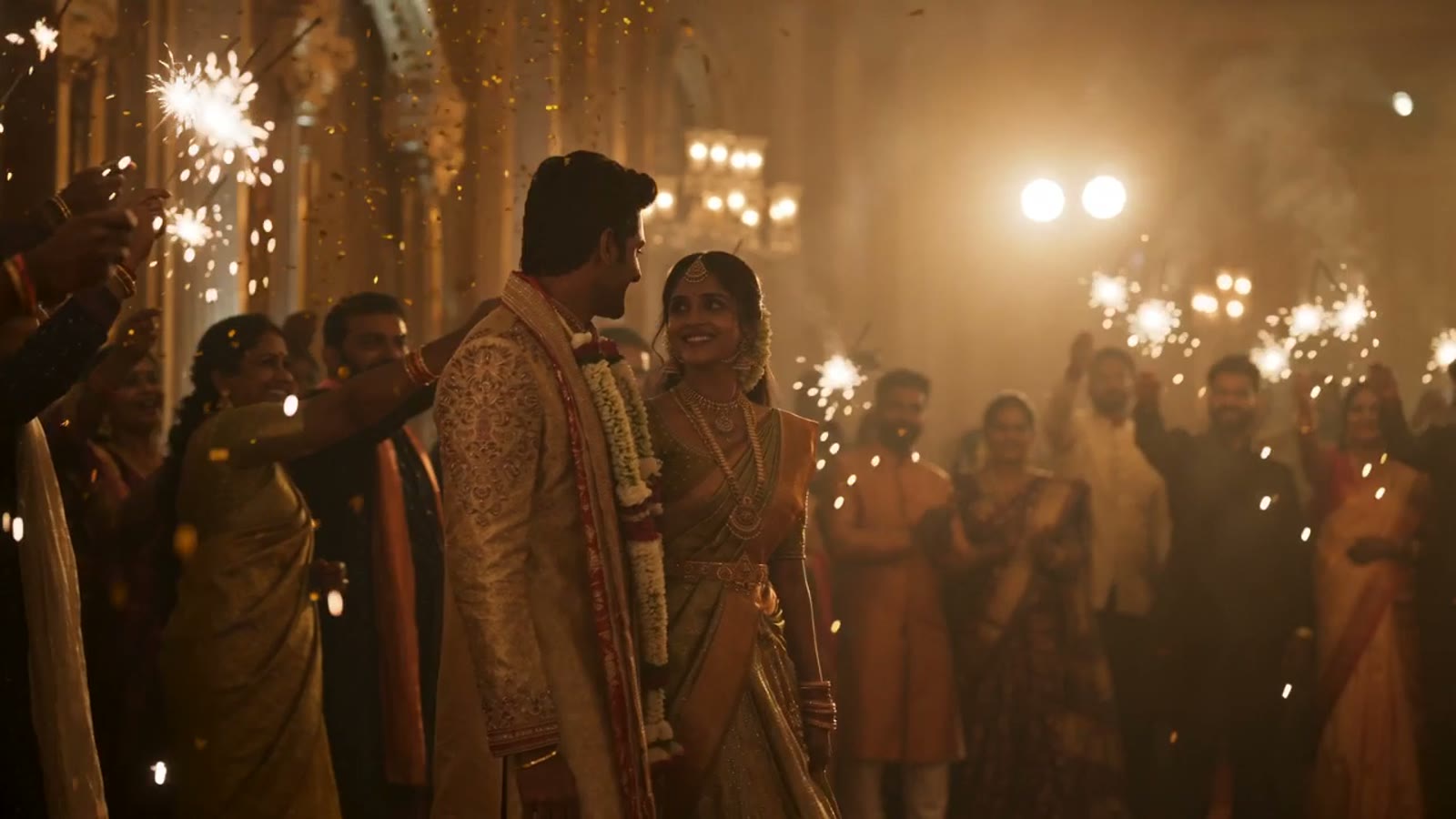 A couple entering their reception under gold confetti